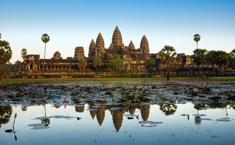 Angkor Wat, an ancient stone temple reflected in a pond during luxury Southeast Asia vacations.