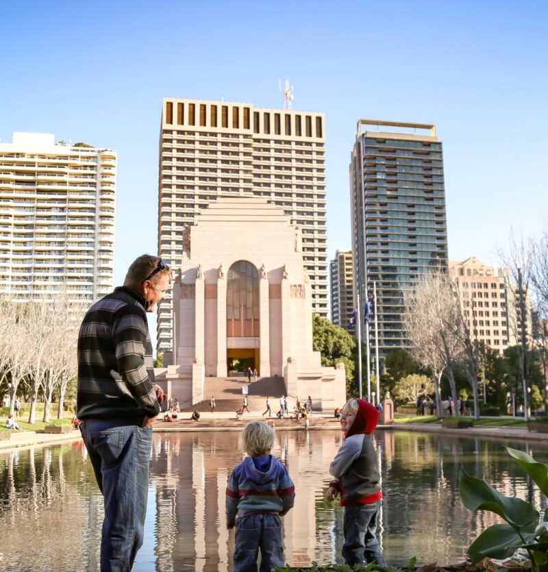 Rear view of family walking together on the beach with the Gold Coast city skyline in the background