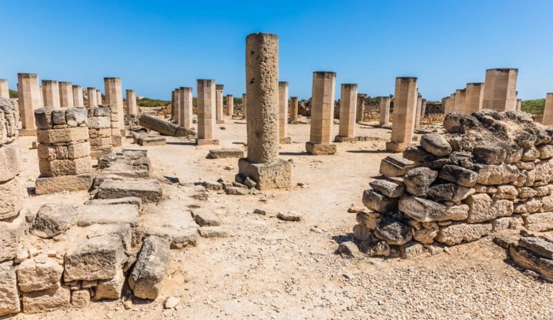Rows of ancient stone columns in a desert landscape featured on luxury Oman holidays.