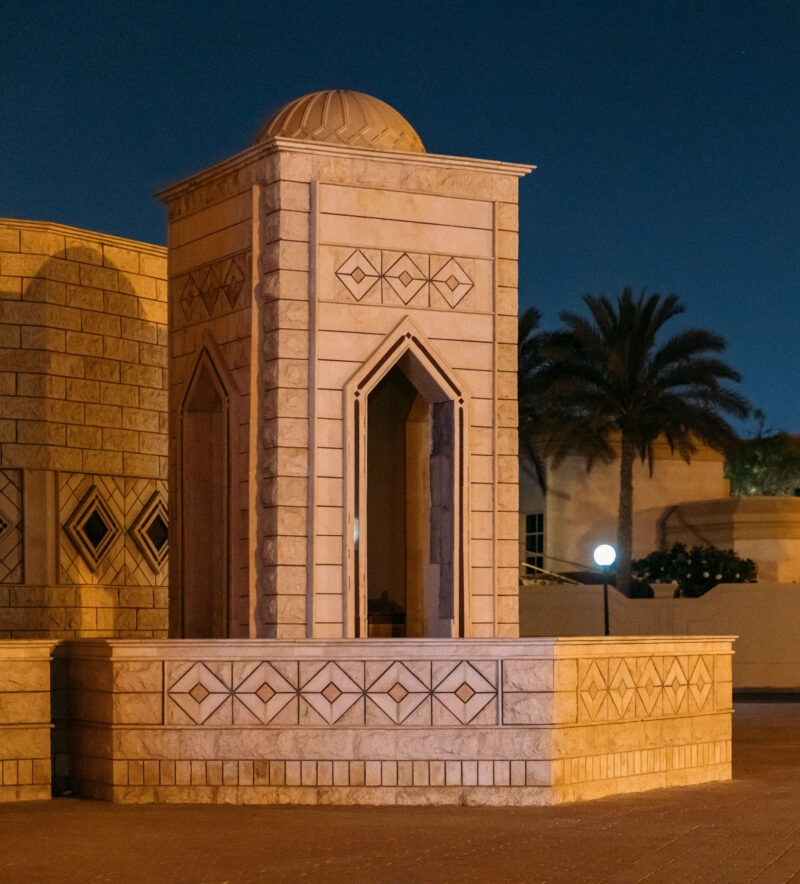 Traditional stone structure with geometric carvings at night for luxury United Arab Emirates tours.
