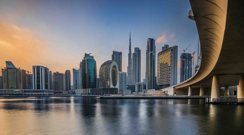 Dubai skyline at sunset featuring the Burj Khalifa and a curved bridge for luxury United Arab Emirates tours.