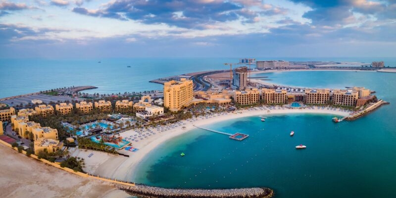 Aerial view of a coastal beach resort and turquoise water for luxury United Arab Emirates tours.