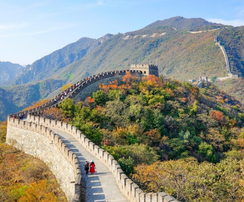 A view of the Great Wall of China surrounded by colorful fall trees on luxury Asia grand tour holidays.