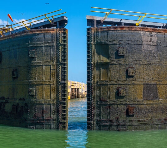 A huge metal lock gate swinging open on the Panama Canal