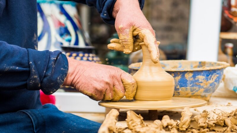 Traditional handmade Iznik Tile. Hands working on ceramic. Handmade vase.