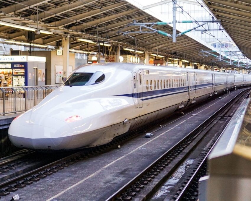 A sleek white high-speed train at a station platform.