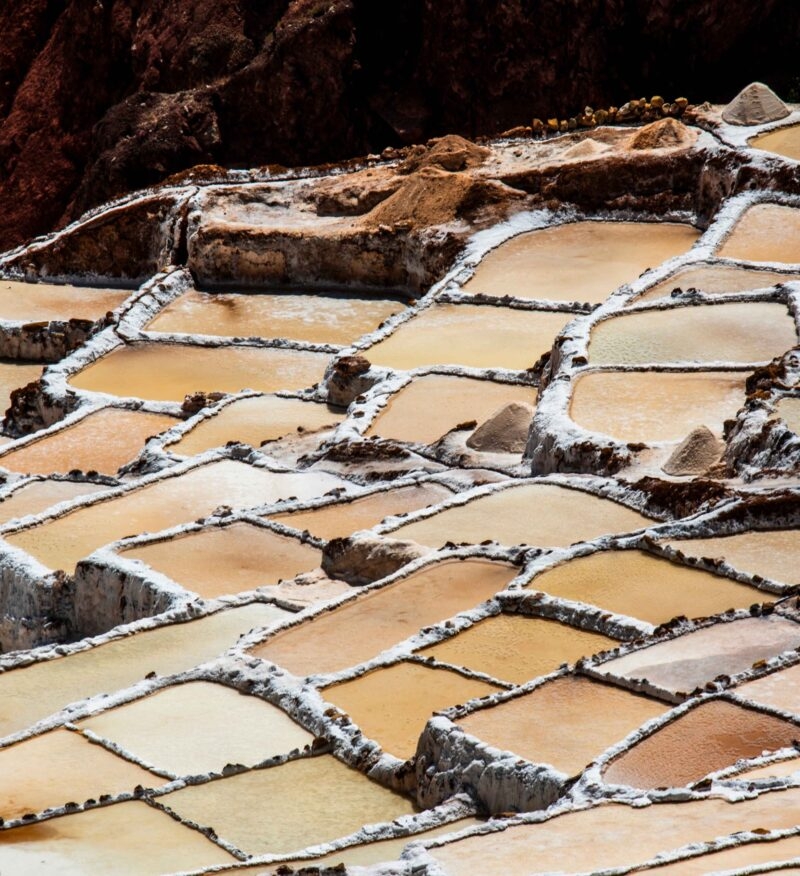 detail of the mountain salt pans with the white of the salt and the brown of the water which is turning into salt with evaporation in Peru in South America