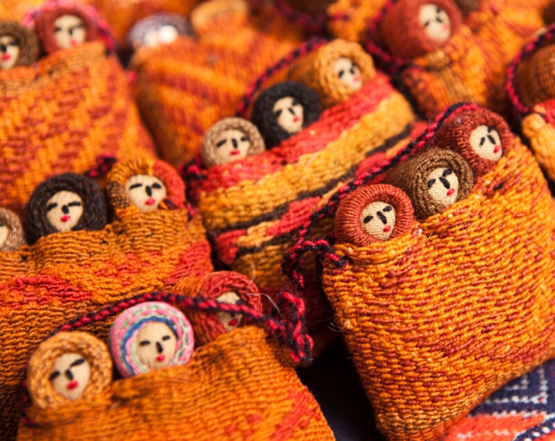 Colorful woven fabric dolls on display.