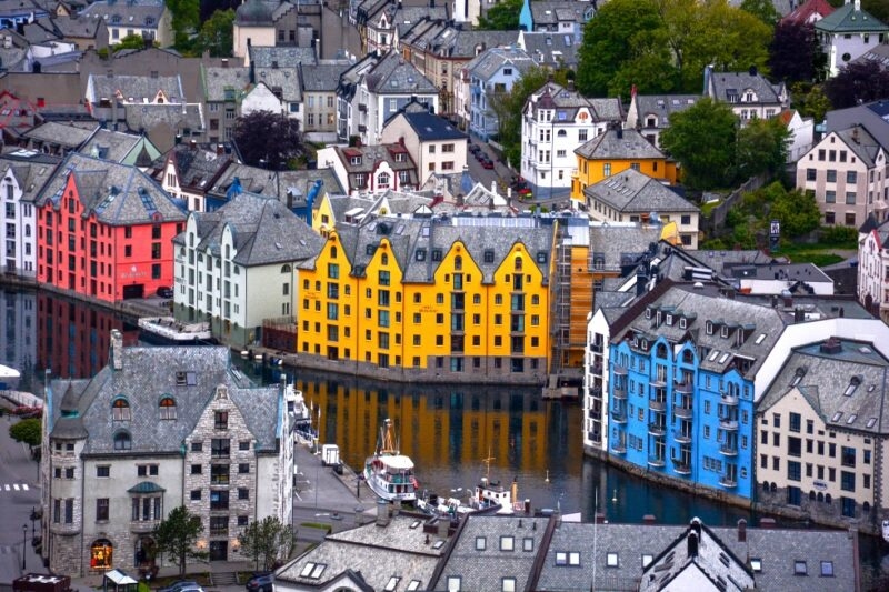 Colorful buildings by the water's edge in a quaint European town, with a boat docked nearby.