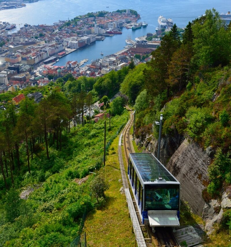 Aerial view of a funicular railway with a city and harbor in the background.
