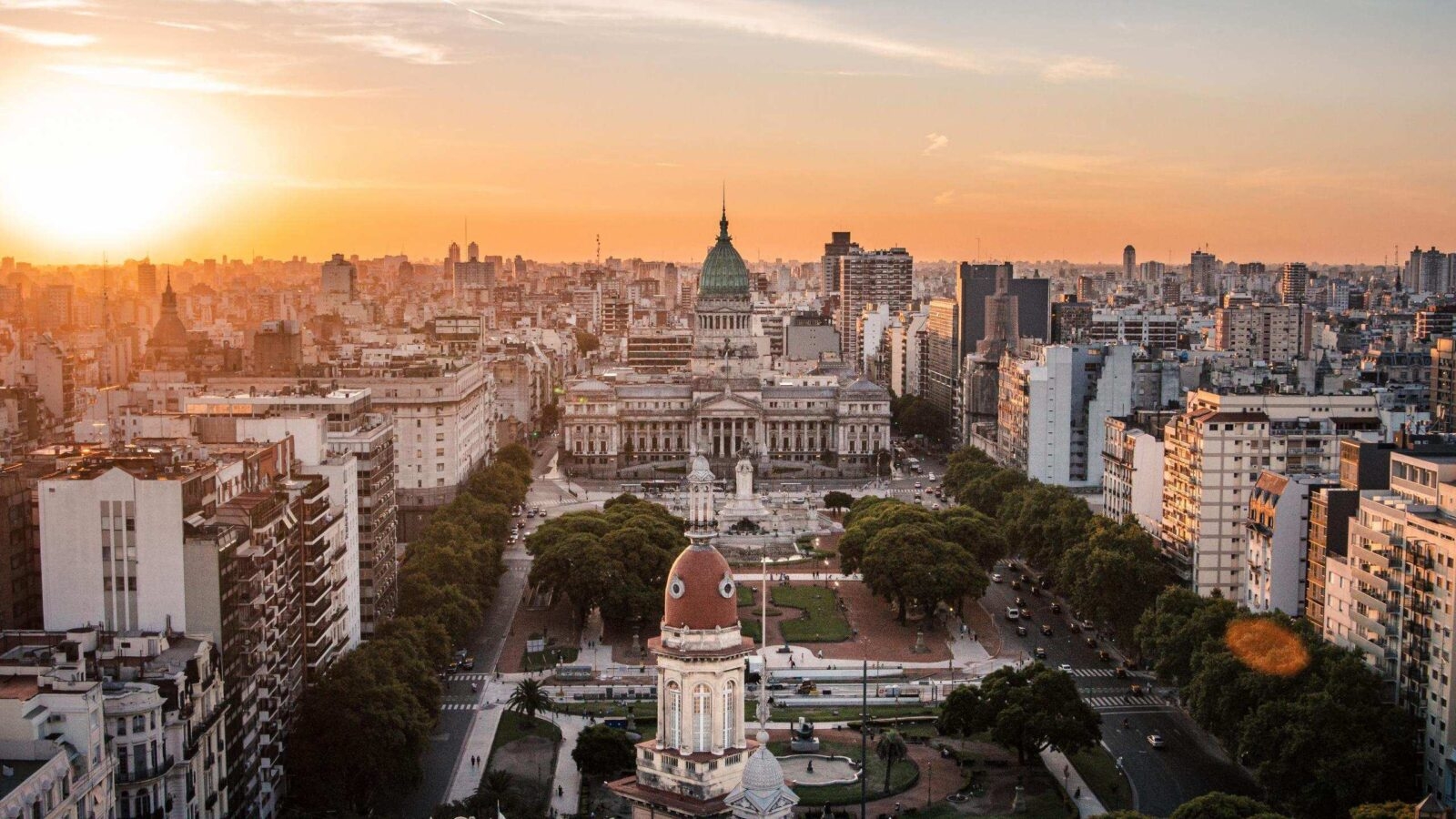 Aerial view of Buenos Aires cityscape at sunset with Congress building in focus.