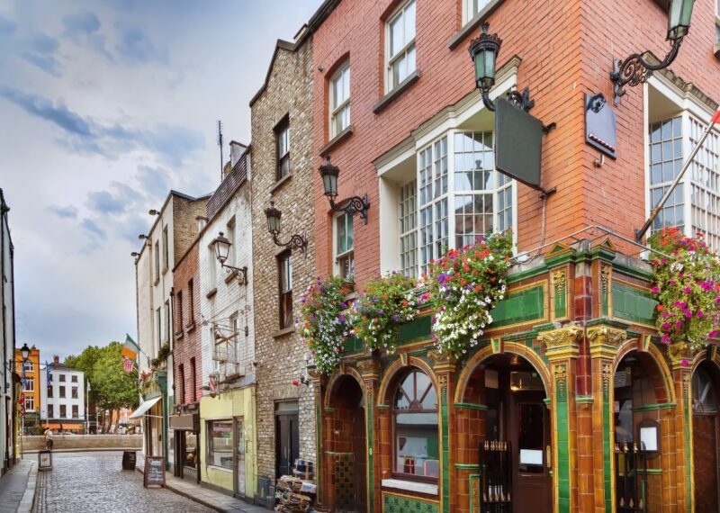 Picturesque street with historic buildings and a pub with floral decoration.