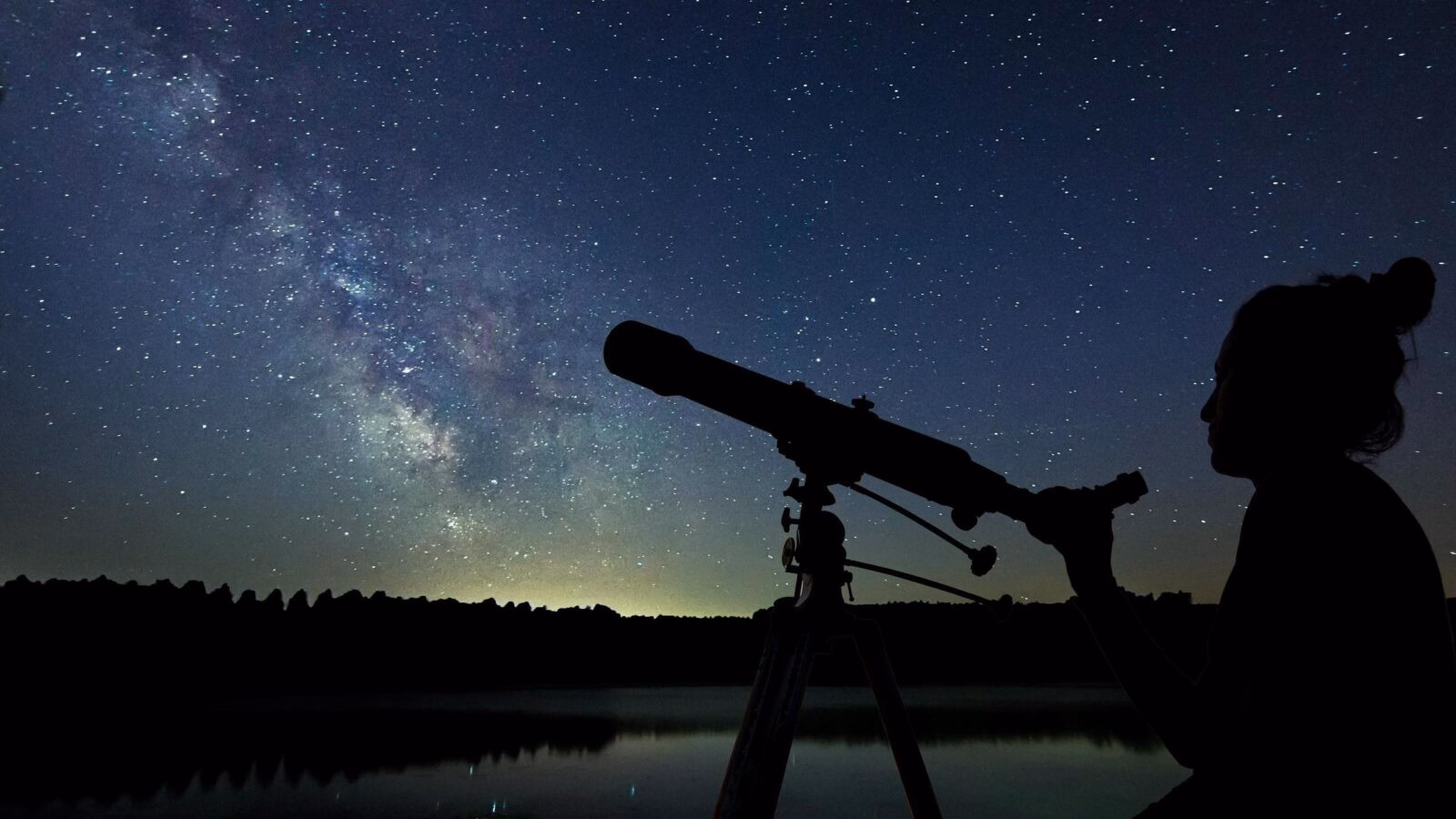 Woman with telescope watching the stars.