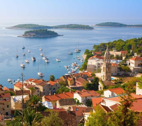 A look of Hvar from above and its shoreline, which skirts a bay filled with yachts.