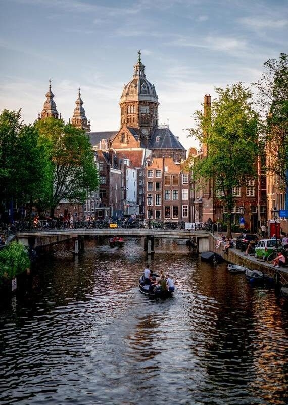 Cruise along the waterways of Amsterdam in a come evening