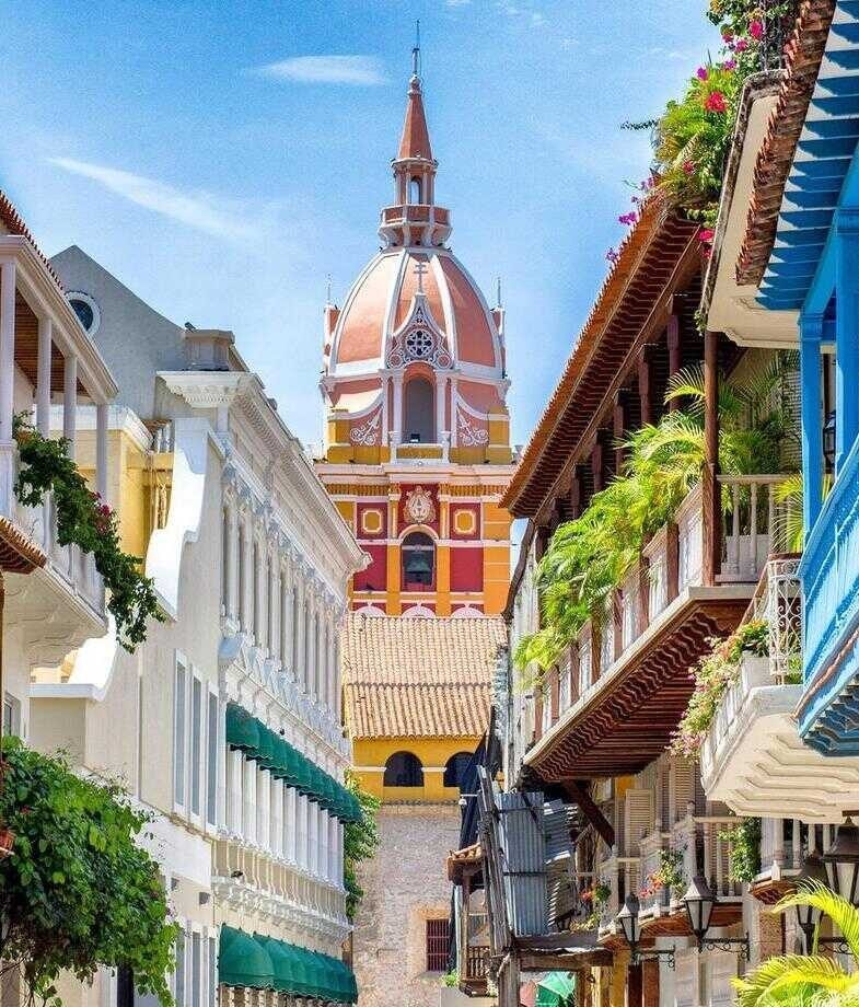 Blue skies are the backdrop for Colombia's colourful building and a group of men deep in the valley of the Coffee Triangle