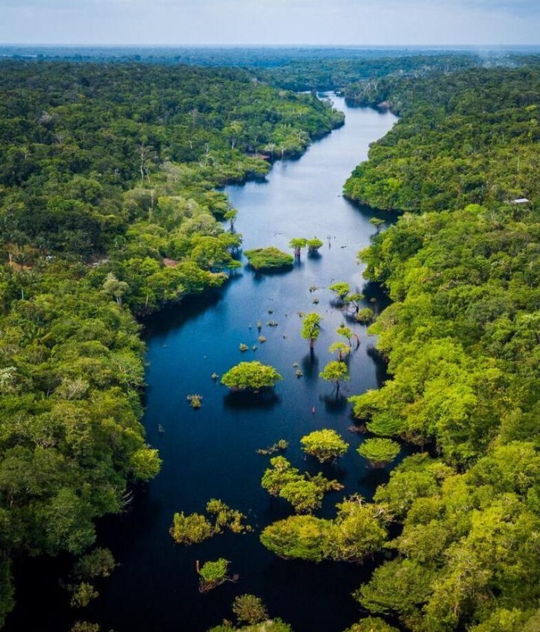 Aerial view of the Amazon Rainforest and the white sand dunes with shimmering pools of Lençóis Maranhenses National Park.
