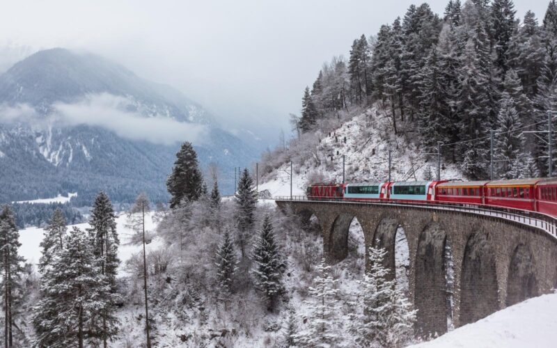 The Glacier Express crossing a stone viaduct in the Swiss Alps