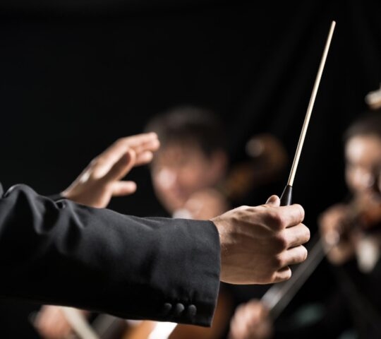 Orchestra conductor on stage classical music concert