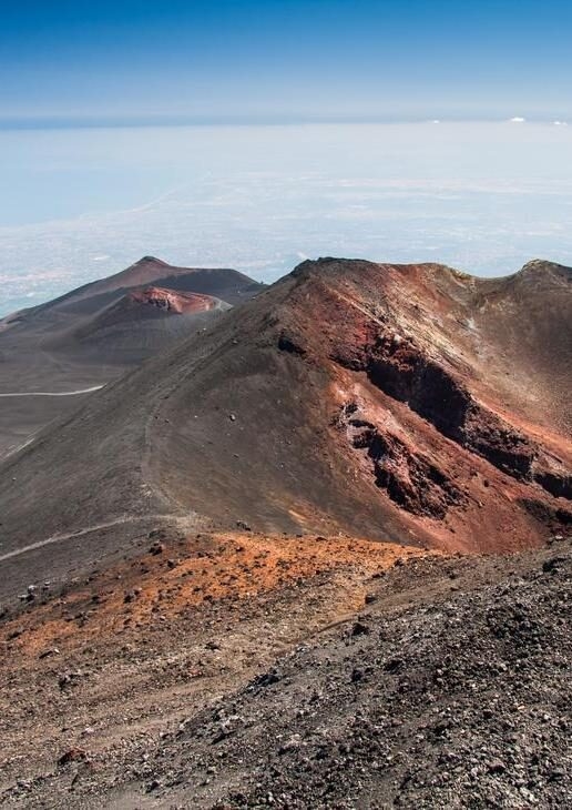 Refreshing summer hikes on Mount Etna in Sicily, the turquoise cove of Polignano a Mare in Puglia, and the island church on Lake Bled in Slovenia.