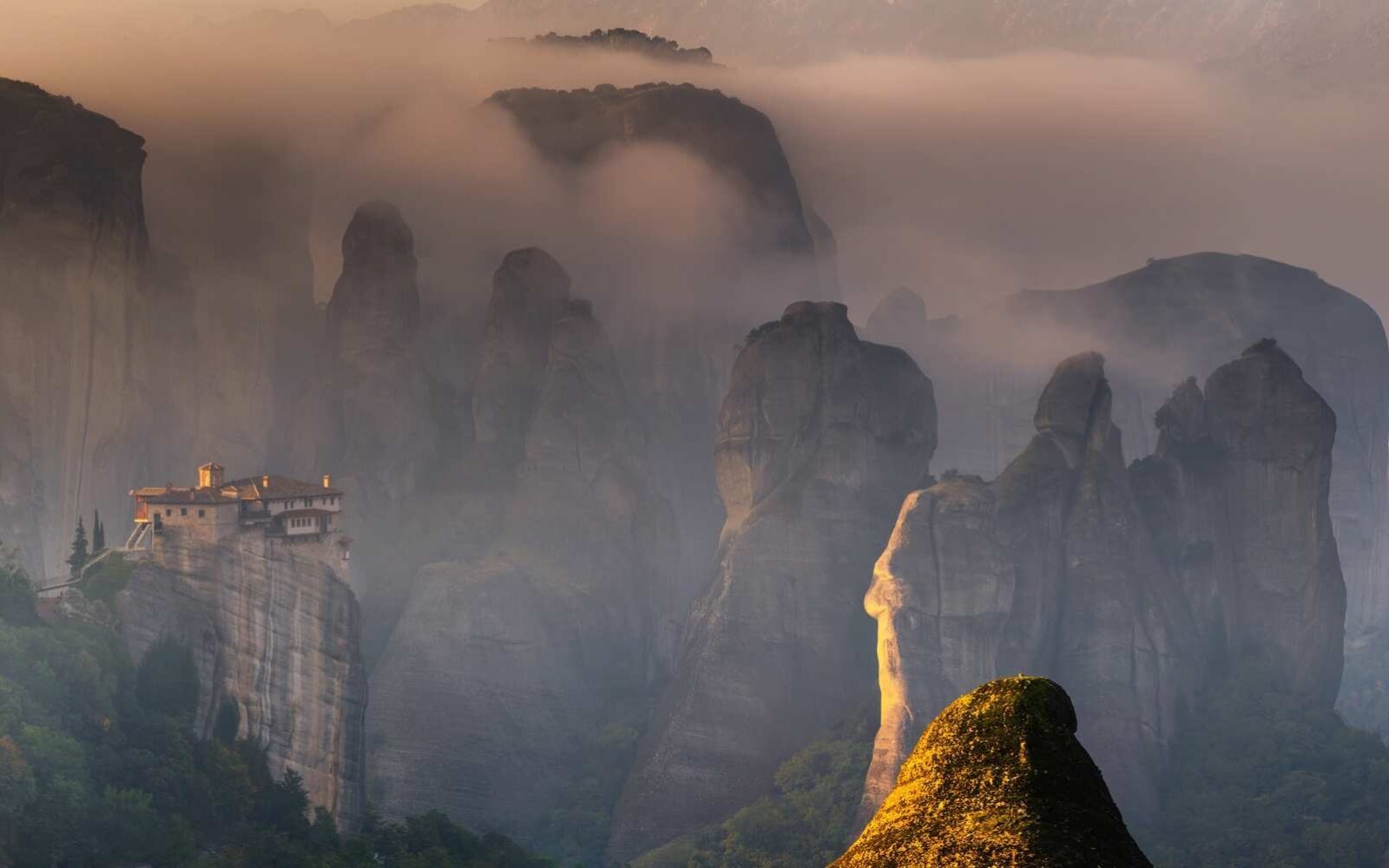 The first rays of sun illuminating the mesmerising mountains of Meteora in northern Greece