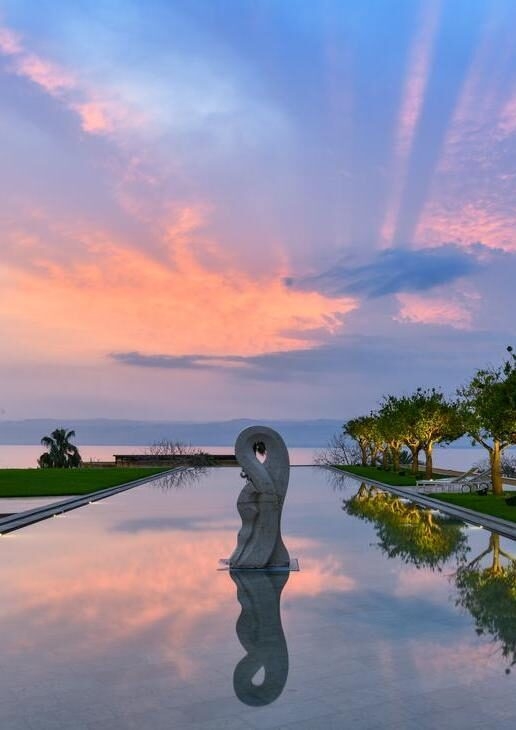 The sculpted timber form of Tierra Patagonia in Chile, the clifftop retreat of Alila Jabal Akhdar in Oman perched high above the canyon, and the serene reflection pools of Kempinski Hotel Ishtar Dead Sea in Jordan at sunset.
