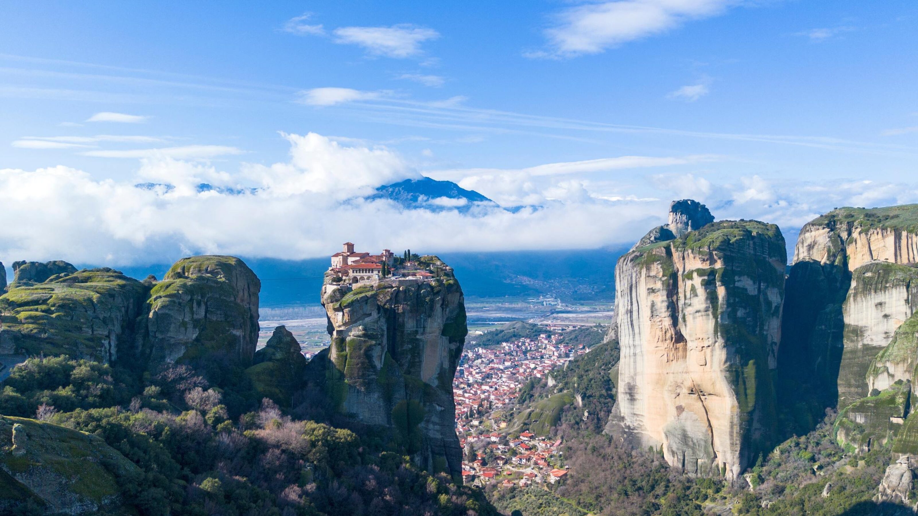 wide view of a monastery on top of a pillar of rock in Meteora, Greece
