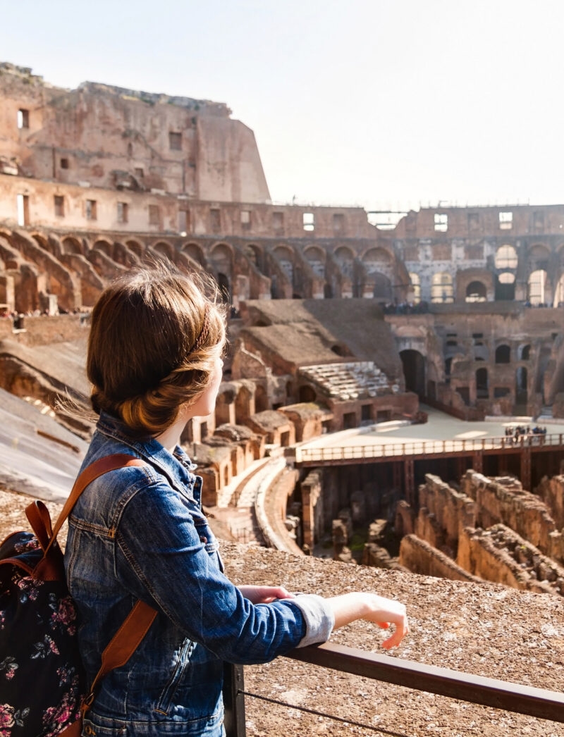 A young woman with a backpack exploring inside the Colosseum