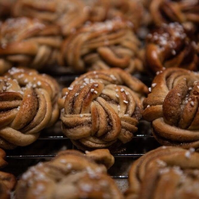 Swedish baked goods. Braided Kardemummabullar, swedish pastries for fika or cardamom rolls, freshly baked and covered in pearl sugar