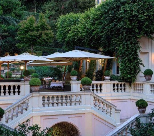 Garden terrace with sheltered tables and lots of greenery at the Hotel de Russie in Rome