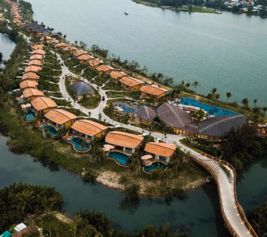 Aerial view of Namia River Retreat showing luxury villas with private pools along a winding river bank.