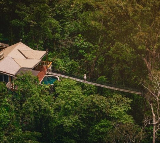 Aerial view of a wooden stilted tent in the middle of the forest at Pacuare Lodge in Costa Rica