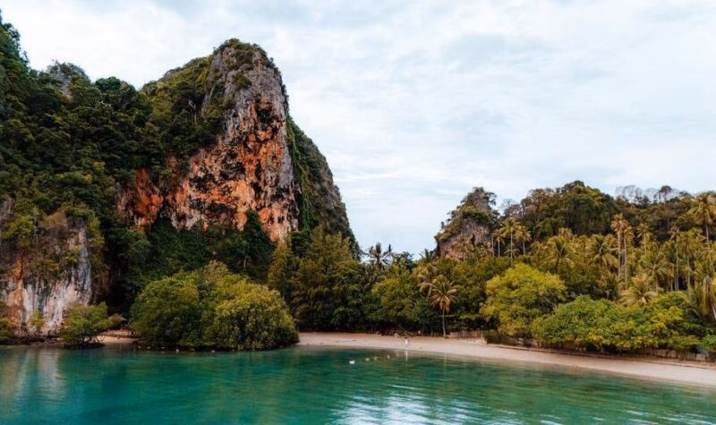 Krabi's beach and coastline with towering limestone cliffs.