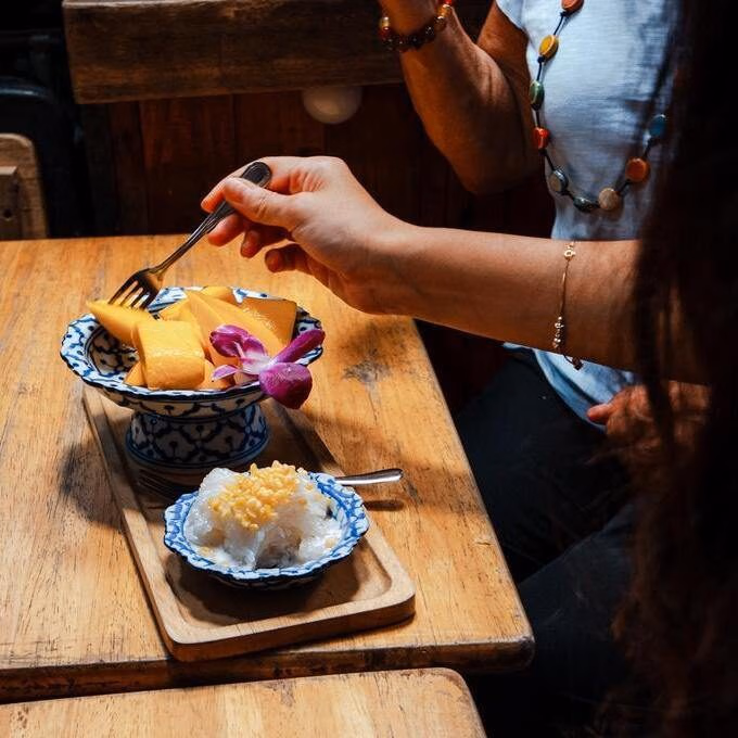 A mother and daughter enjoy mango sticky rice, a traditional Thai dessert.