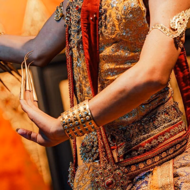 A traditional Thai dancer with a close up off the clothing and accessories.
