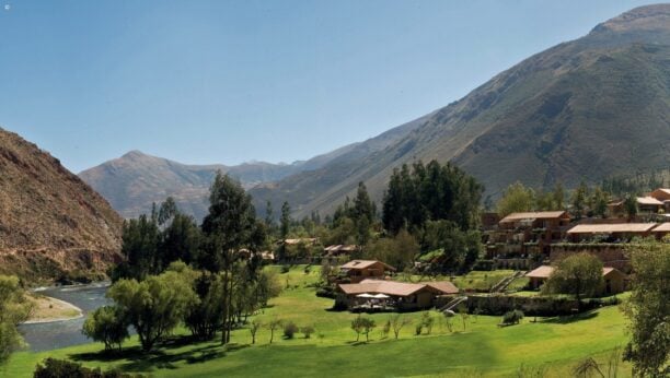 Panoramic view of Hotel Rio Sagrado surrounded by vast mountains of the Sacred Valley, Peru
