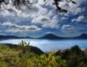 Panoramic view of Lake Atitlan in Guatemala, surrounded by mountain peaks on a sunny day