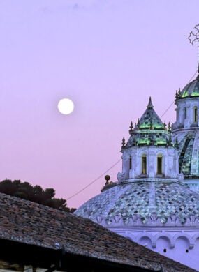 Full moon casting soft light on the Basilica del Voto Nacinoal in Quito, Ecuador at twilight
