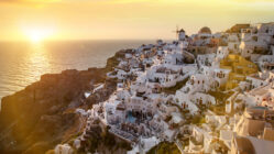 Picturesque sunset illuminating the white buildings of the Oia resort, Santorini