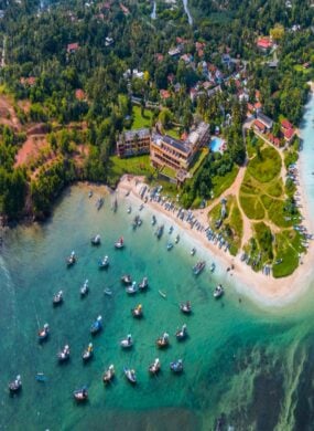 Aerial panorama of the south coast of Sri Lanka (Near Weligama), with small boats moored out to sea and buildings nestled between the trees