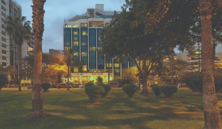 External view of the front of the Belmond Miraflores Park Hotel (Lime, Peru) at twilight, taken from the surrounding parkland