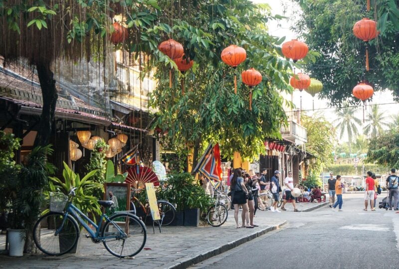 A bustling Hoi An street with lanterns hanging overhead