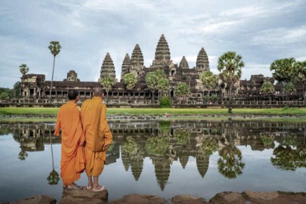 Two Vietnamese monks stand and look to Angkor Wat in Siem Reap, Cambodia