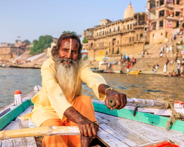 Sadhu rowing boat on the holy Ganges River in Varanasi