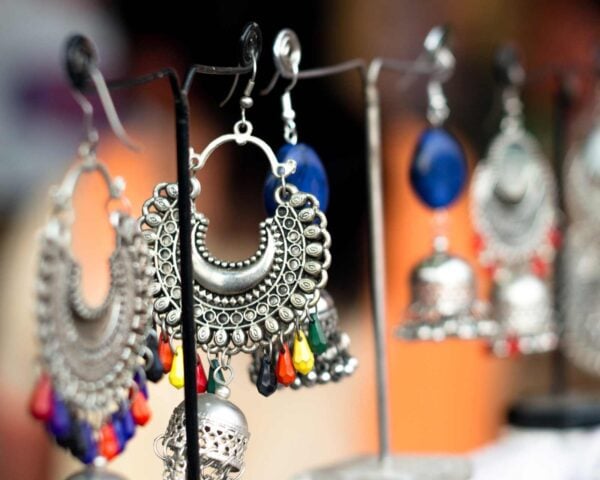 Silver and beaded earrings hanging on small stands