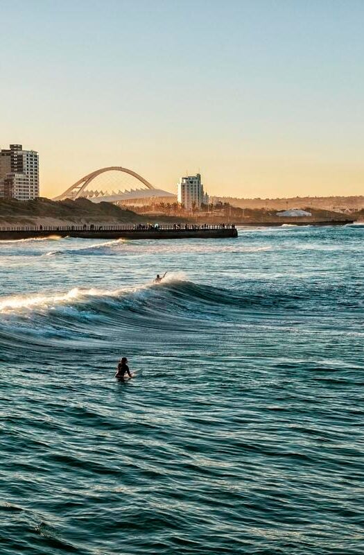 Surfers Enjoying the Waves During Sunset in Durban, South Africa