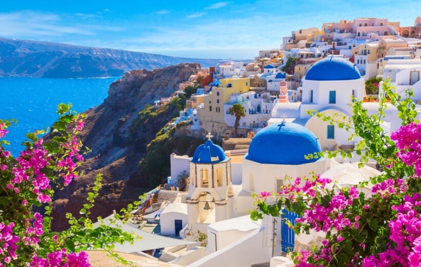 Santorini island, Greece. Oia town traditional white houses and churches with blue domes over the Caldera, Aegean sea.