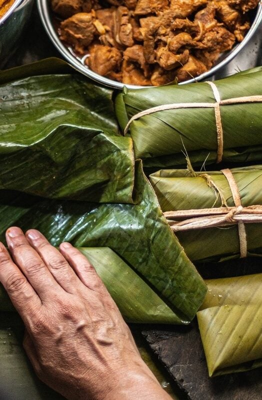 A person preparing tamales, traditional Colombian food