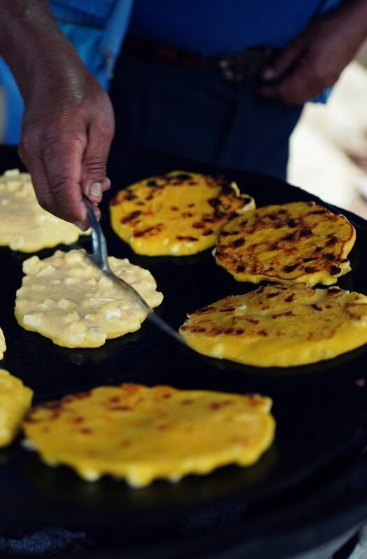 Freshly prepared arepas with cheese on a street stall