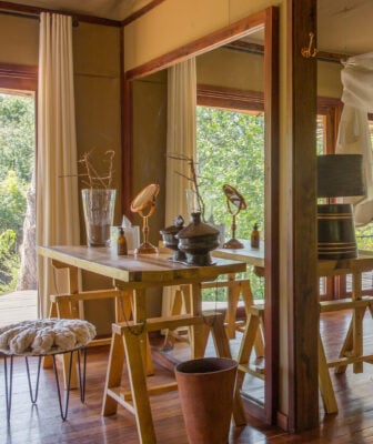 Writing desk in Mwiba Lodge with a small mirror and a vase set on top